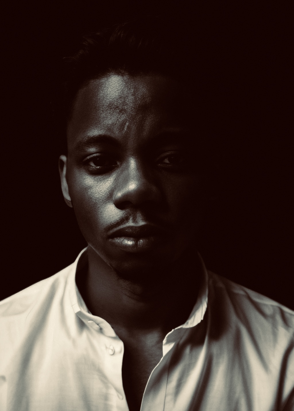 A shadow-lit portrait of Olatunji
